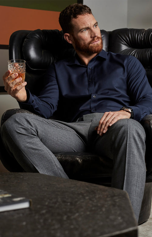 man sitting down and wearing merino wol shirt in navy blue color with long sleeves from Wolk