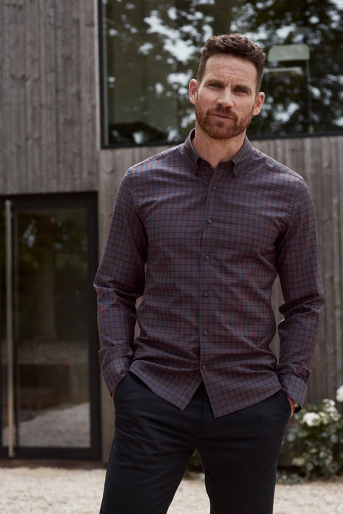 man wearing burgundy navy check merino wool shirt with button down collar and corozo buttons