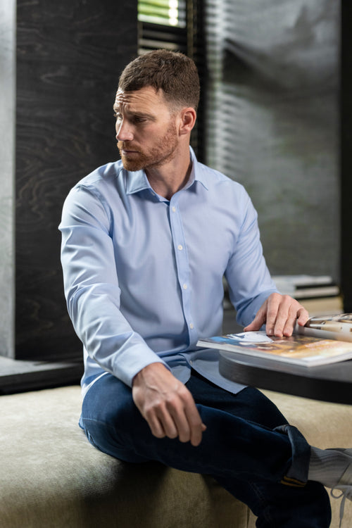 man wears a light blue merino wool shirt from Wolk with a classic collar