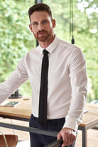 Man wearing a long sleeve merino dress shirt in white with tie