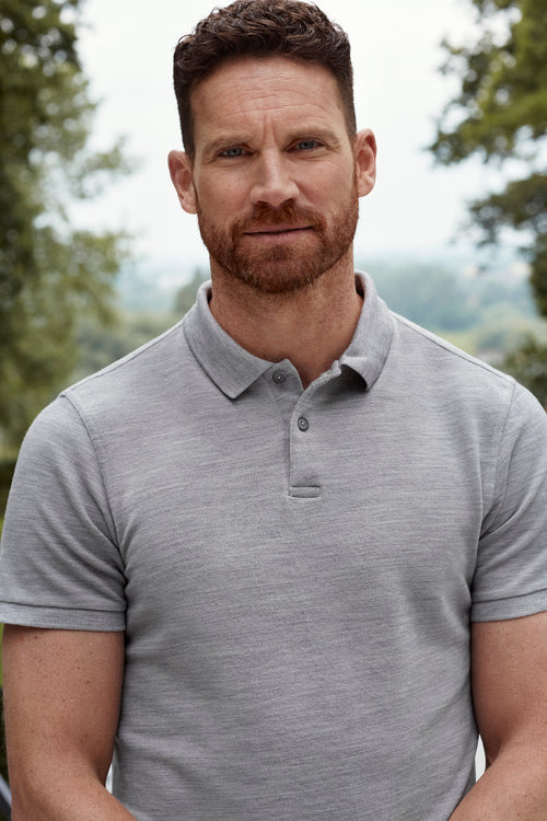 close up of man wearing merino wool polo in grey melange color with shortsleeves