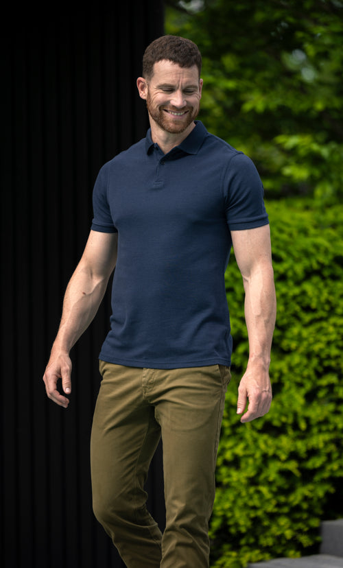 Man wearing short sleeve merino wool polo with rib cuff and collar in navy blue
