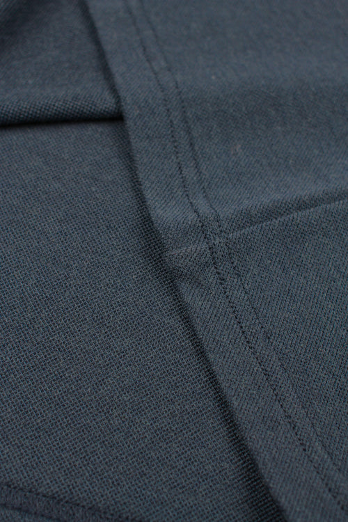 detail of pique fabric on navy polo made of merino wool