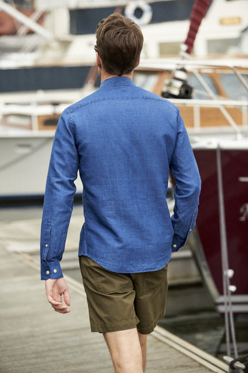 Backside of man wearing blue indigo dyed linen shirt with chest pocket